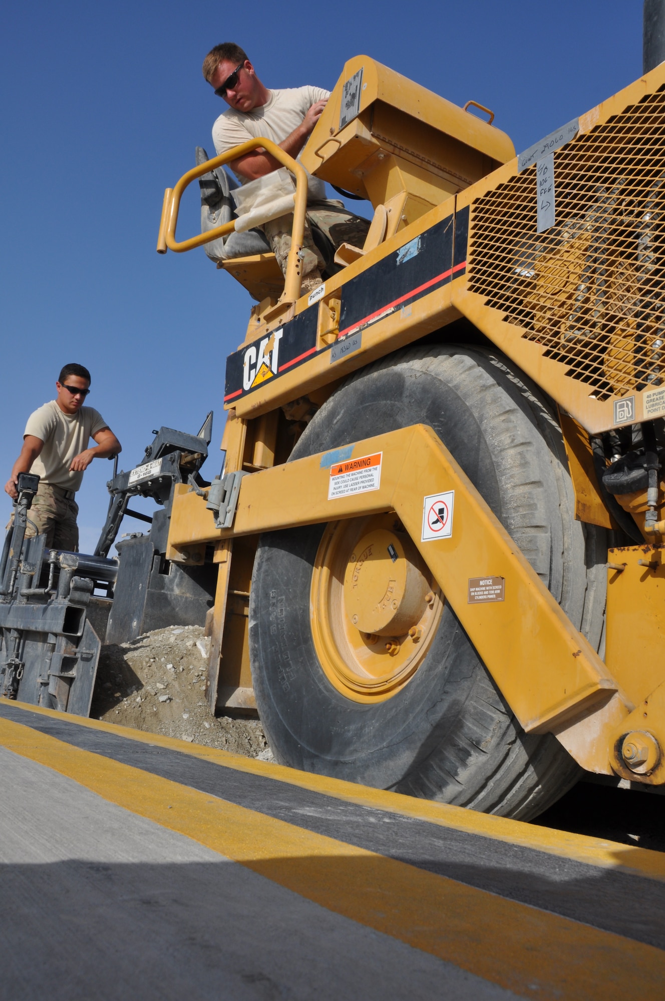 Airman 1st Class Juan Rigioni, a native of Dallas, and Staff Sgt. Justin Wycoff, a native of James, Mo., both from the 557th RED HORSE Squadron, are deployed from Malmstrom Air Force Base, Mont. The two Airmen are working on a perimeter flightline road construction project at Bagram Airfield, Afghanistan, Aug. 19. The project is scheduled to be completed by the end of August. (U.S. Air Force photo/Tech. Sgt. Rob Hazelett)
