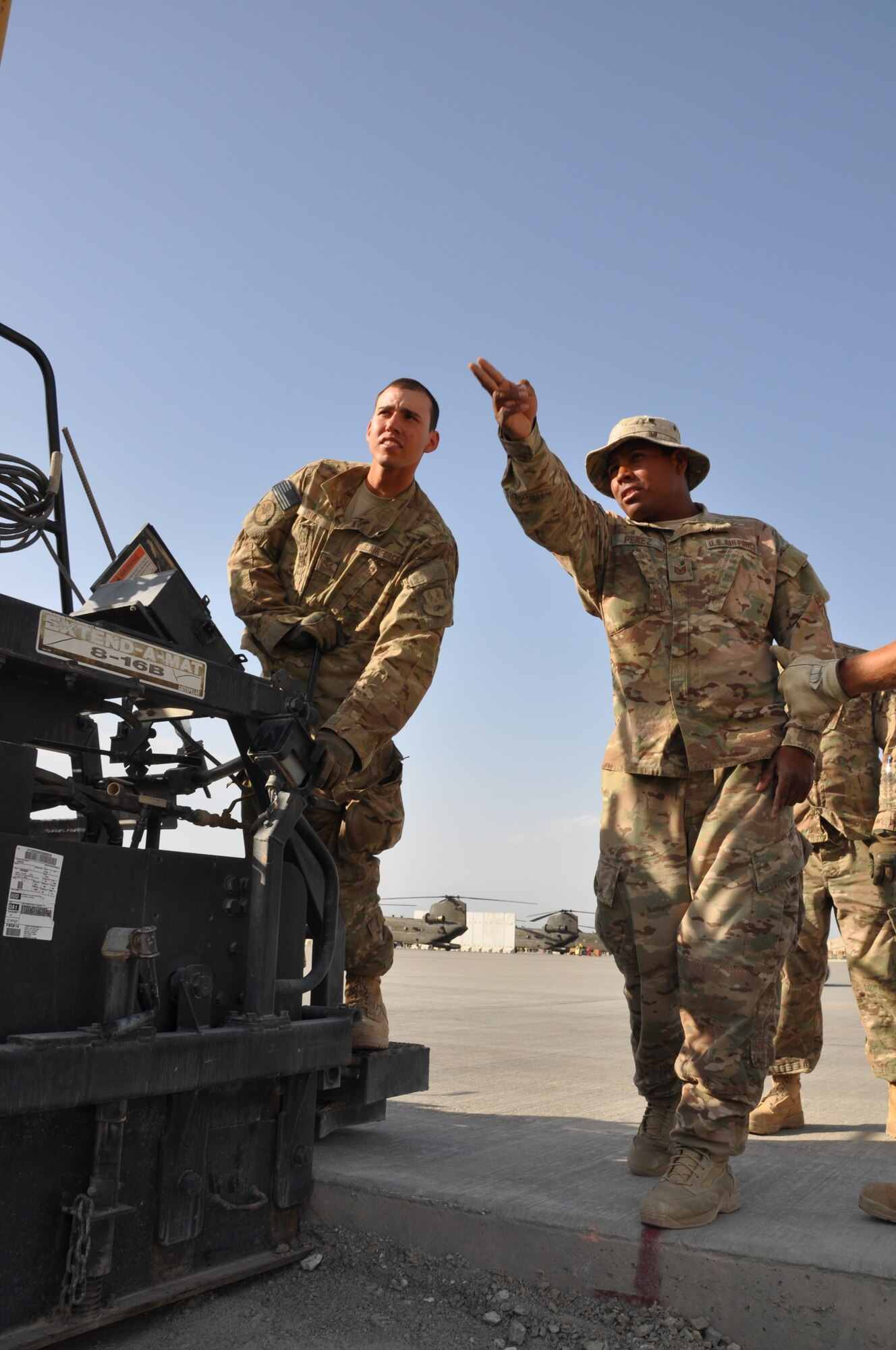Airman 1st Class Andrew Diaz, a native of Corona, Calif., and Tech. Sgt. Elvis Perez, a native of Clarksville, Tenn., both from the 557th RED HORSE Squadron, are deployed from Malmstrom Air Force Base, Mont. The two Airmen are working on a perimeter flightline road construction project at Bagram Airfield, Afghanistan, Aug. 19. The project is scheduled to be completed by the end of August. (U.S. Air Force photo/Tech. Sgt. Rob Hazelett)