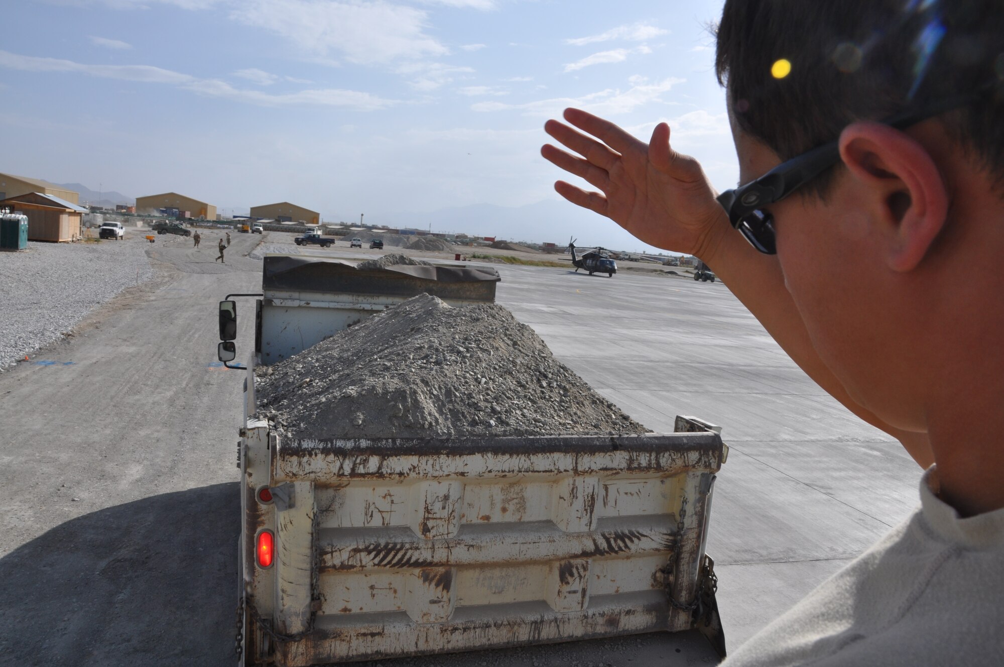 Airman 1st Class Juan Rigioni, 557th RED HORSE Squadron, is deployed from Malmstrom Air Force Base, Mont., and a native of Dallas, is working on the perimeter flightline road construction project at Bagram Airfield, Afghanistan, Aug. 19. The project is scheduled to be completed by the end of August. (U.S. Air Force photo/Tech. Sgt. Rob Hazelett)
