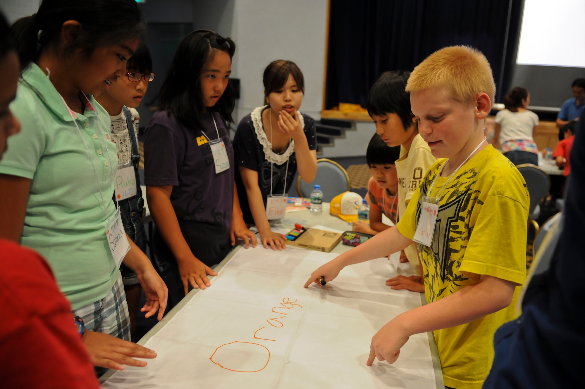 YOKOTA AIR BASE, Japan -- Children plan how they will decorate their team flag during the International Exchange Summer Sleepover, Aug. 10, 2013, at Yokota Air Base.  Each team had the job of deciding on a name and decorating their flag before they participated in a water balloon toss game.  (U.S. Air Force photo by Airman 1st Class Meagan Schutter)