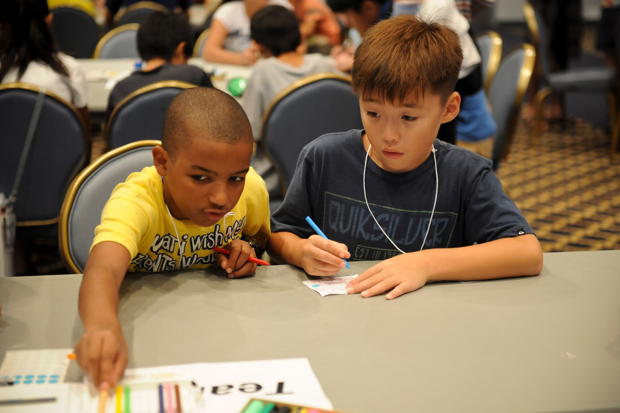 YOKOTA AIR BASE, Japan -- Left, Darius Middleton reaches for a colored pencil during the International Exchange Summer Sleepover, Aug. 10, 2013, at the Taiyo Community Center at Yokota Air Base, Japan.  Children were encouraged to work with and meet new people during the sleepover.  (U.S. Air Force photo by Airman 1st Class Meagan Schutter)