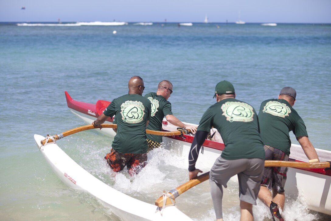 Army Master Sgt. Jim Keen, noncommissioned officer in charge for Warrior Transition Battalion, based out of Schofield Barracks, helps his fellow soldiers push their canoe into the water during the Wounded Warrior Canoe Regatta at Fort DeRussy Beach, Aug. 18, 2013. (U.S. Marine Corps photo by Lance Cpl. Janelle Y. Chapman)