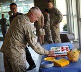 Chief Petty Officer David S. Beason, the senior enlisted leader for Marine Centered Medical Home makes the first cuts to the celebratory cake following the ribbon cutting ceremony at the French Creek Medical Clinic aboard Camp Lejeune, N.C., Aug. 22, 2013.  Beason said the consolidated nature of the clinic also improves communication between service members’ various medical providers and the facility’s staff, who have proven instrumental to the program’s success. (U.S. Marine Corps photo by Lance Cpl. Shawn Valosin)