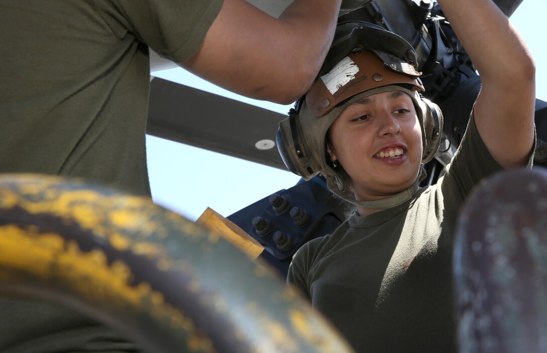 Lance Cpl. Amanda Martinez, a flight line mechanic with Marine Heavy Helicopter Squadron 465 "Warhorses" and a San Antonio, native, speaks to a peer while performing maintenance on a CH-53E Super Stallion aboard Marine Corps Air Station Miramar, Calif., Aug 20. The aircraft was one of five flown to Colorado Springs during a deployment for training Aug. 21 to Aug. 29.