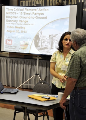 KINGMAN, Ariz. – Fran Firouzi, a project manager for the U.S. Army Corps of Engineers Los Angeles District, talks with a member of the public at an informational public meeting held Aug. 20 at the Fraternal Order of the Eagles meeting facility in Kingman, Ariz. about the upcoming time-critical removal action work at site of the former Kingman Ground-to-Ground Gunnery Range. The work at the site will "abate, prevent, minimize, stabilize, mitigate, or eliminate the release or threat of release” of contaminants according to 40 Code of Federal Regulations 300.415(b) (1) at up to 42 properties in the area in addition to the ten properties already completed.  