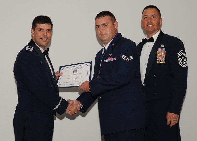 Senior Airman Benjamin Wilkes, 2nd Aircraft Maintenance Squadron, receives an Airman Leadership School graduation certificate from Col. Andrew Gebara, 2nd Bomb Wing commander, on Barksdale Air Force Base, La., June 21, 2013. (U.S. Air Force photo).