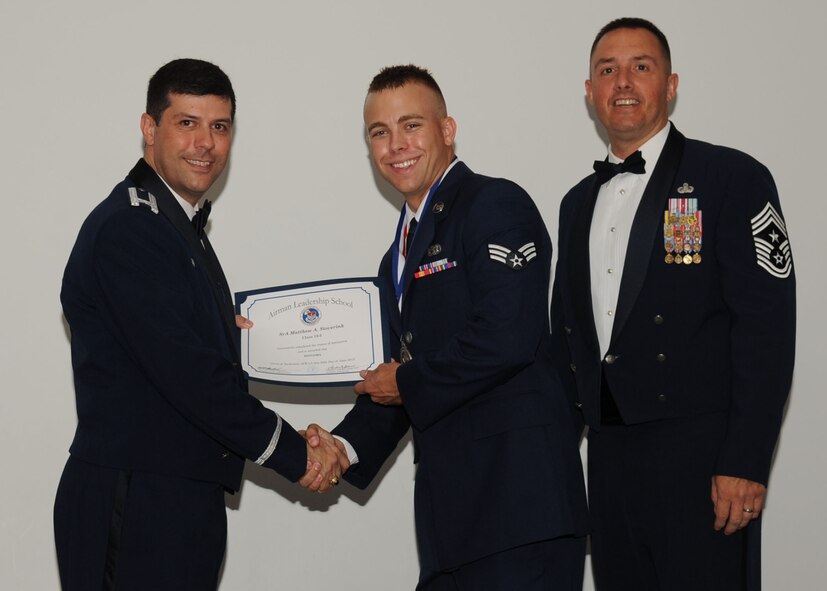 Senior Airman Matthew Stoverink, 2nd Maintenance Squadron, receives an Airman Leadership School graduation certificate from Col. Andrew Gebara, 2nd Bomb Wing commander, on Barksdale Air Force Base, La., June 21, 2013. (U.S. Air Force photo).