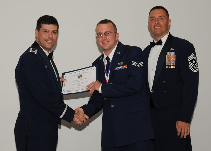 Senior Airman Walter Scharf III, 2nd Munitions Squadron, receives an Airman Leadership School graduation certificate from Col. Andrew Gebara, 2nd Bomb Wing commander, on Barksdale Air Force Base, La., June 21, 2013. (U.S. Air Force photo).