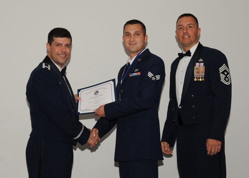 Senior Airman David Schaaf, 2nd Munitions Squadron, receives an Airman Leadership School graduation certificate from Col. Andrew Gebara, 2nd Bomb Wing commander, on Barksdale Air Force Base, La., June 21, 2013. (U.S. Air Force photo).