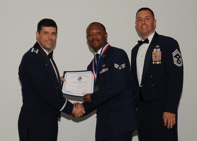 Senior Airman Wayne Muhammad, 2nd Aircraft Maintenance Squadron, receives an Airman Leadership School graduation certificate from Col. Andrew Gebara, 2nd Bomb Wing commander, on Barksdale Air Force Base, La., June 21, 2013. (U.S. Air Force photo).