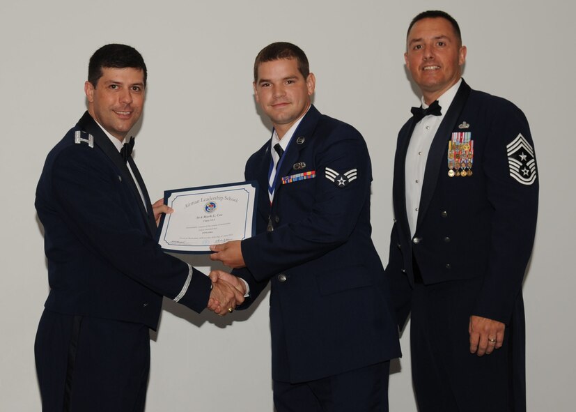 Senior Airman Mark Cox, 2nd Aircraft Maintenance Squadron, receives an Airman Leadership School graduation certificate from Col. Andrew Gebara, 2nd Bomb Wing commander, on Barksdale Air Force Base, La., June 21, 2013. (U.S. Air Force photo).