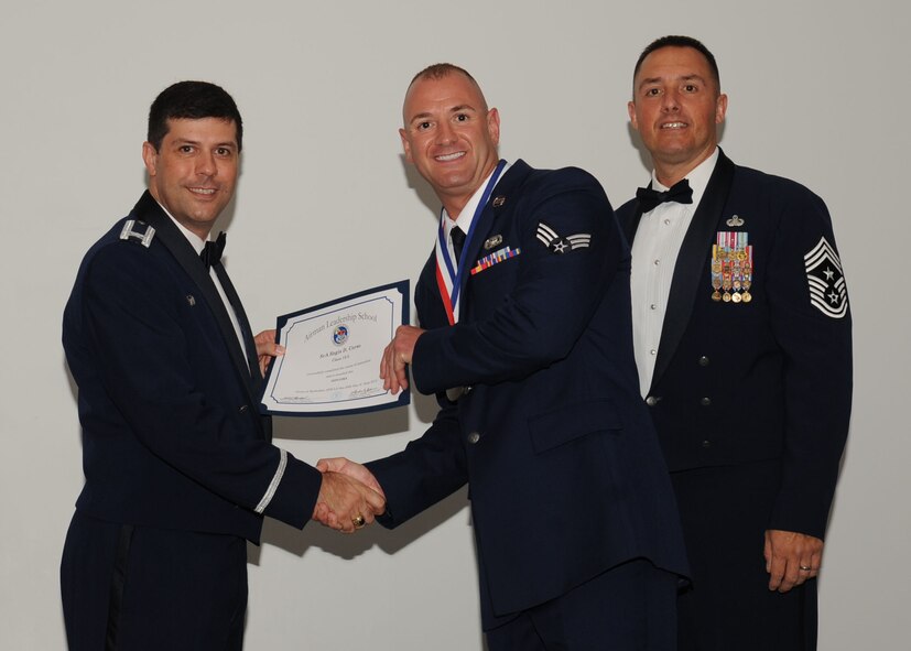 Senior Airman Regis Corso, 911th Mission Support Group, receives an Airman Leadership School graduation certificate from Col. Andrew Gebara, 2nd Bomb Wing commander, on Barksdale Air Force Base, La., June 21, 2013. (U.S. Air Force photo).