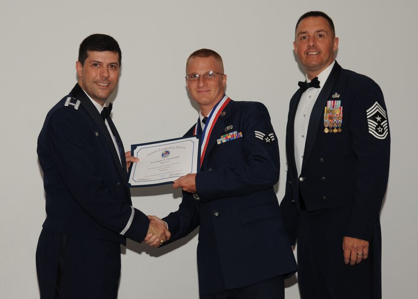 Senior Airman Jason Carniewski, 2nd Civil Engineer Squadron, receives an Airman Leadership School graduation certificate from Col. Andrew Gebara, 2nd Bomb Wing commander, on Barksdale Air Force Base, La., June 21, 2013. (U.S. Air Force photo).