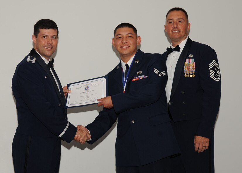 Senior Airman Robert Borja, 2nd Maintenance Squadron, receives an Airman Leadership School graduation certificate from Col. Andrew Gebara, 2nd Bomb Wing commander, on Barksdale Air Force Base, La., June 21, 2013. (U.S. Air Force photo).
