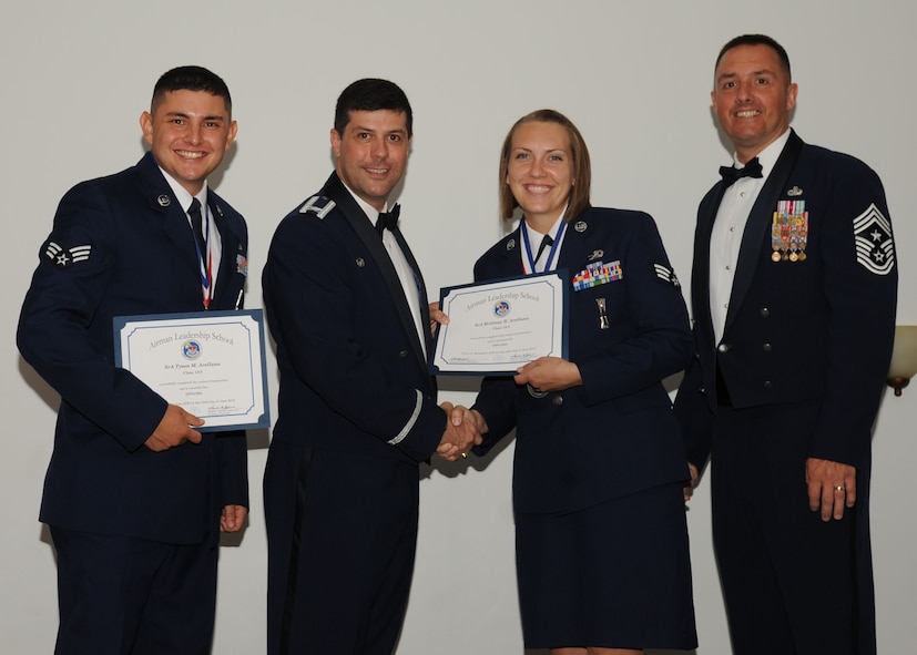 Senior Airman Brittany Arellano, 2nd Munitions Squadron, receives an Airman Leadership School graduation certificate from Col. Andrew Gebara, 2nd Bomb Wing commander, on Barksdale Air Force Base, La., June 21, 2013. (U.S. Air Force photo).