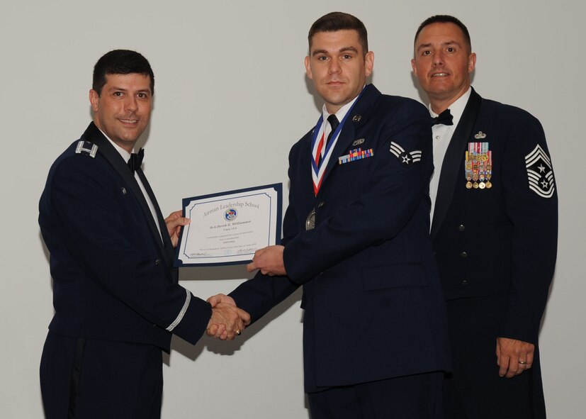 Senior Airman Dyrek Williamson, 2nd Aircraft Maintenance Squadron, receives an Airman Leadership School graduation certificate from Col. Andrew Gebara, 2nd Bomb Wing commander, on Barksdale Air Force Base, La., June 21, 2013. (U.S. Air Force photo).