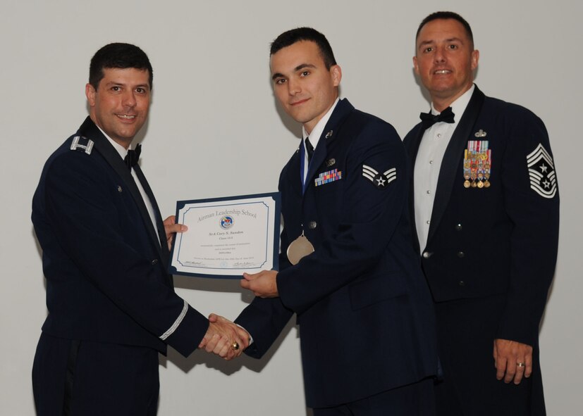 Senior Airman Cory Sanden, 2nd Aircraft Maintenance Squadron, receives an Airman Leadership School graduation certificate from Col. Andrew Gebara, 2nd Bomb Wing commander, on Barksdale Air Force Base, La., June 21, 2013. (U.S. Air Force photo).