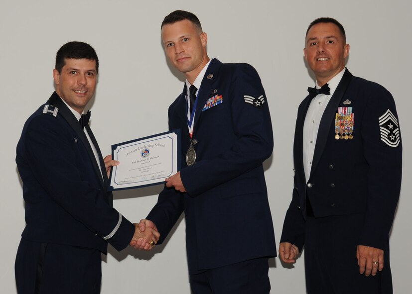 Senior Airman Brenton Mauney, 2nd Munitions Squadron, receives an Airman Leadership School graduation certificate from Col. Andrew Gebara, 2nd Bomb Wing commander, on Barksdale Air Force Base, La., June 21, 2013. (U.S. Air Force photo).