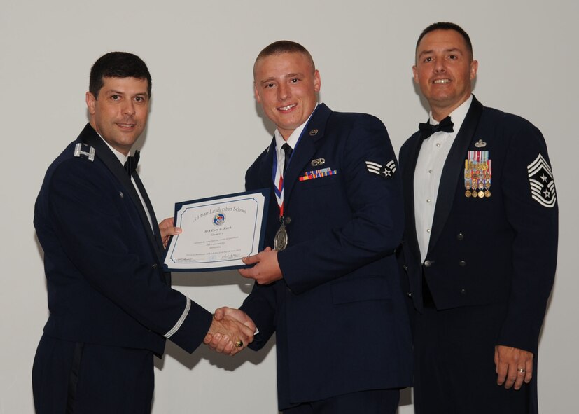 Senior Airman Cory Koch, 2nd Maintenance Squadron, receives an Airman Leadership School graduation certificate from Col. Andrew Gebara, 2nd Bomb Wing commander, on Barksdale Air Force Base, La., June 21, 2013. (U.S. Air Force photo).