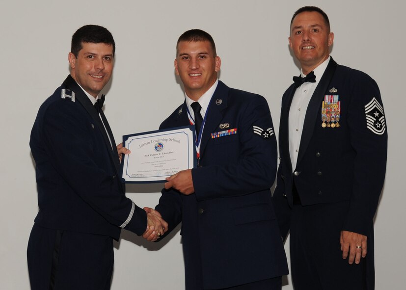 Senior Airman Colton Chandler, 2nd Maintenance Squadron, receives an Airman Leadership School graduation certificate from Col. Andrew Gebara, 2nd Bomb Wing commander, on Barksdale Air Force Base, La., June 21, 2013. (U.S. Air Force photo).