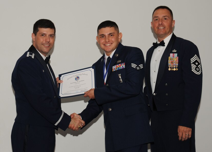 Senior Airman Tyson Arellano, 2nd Munitions Squadron, receives an Airman Leadership School graduation certificate from Col. Andrew Gebara, 2nd Bomb Wing commander, on Barksdale Air Force Base, La., June 21, 2013. (U.S. Air Force photo).