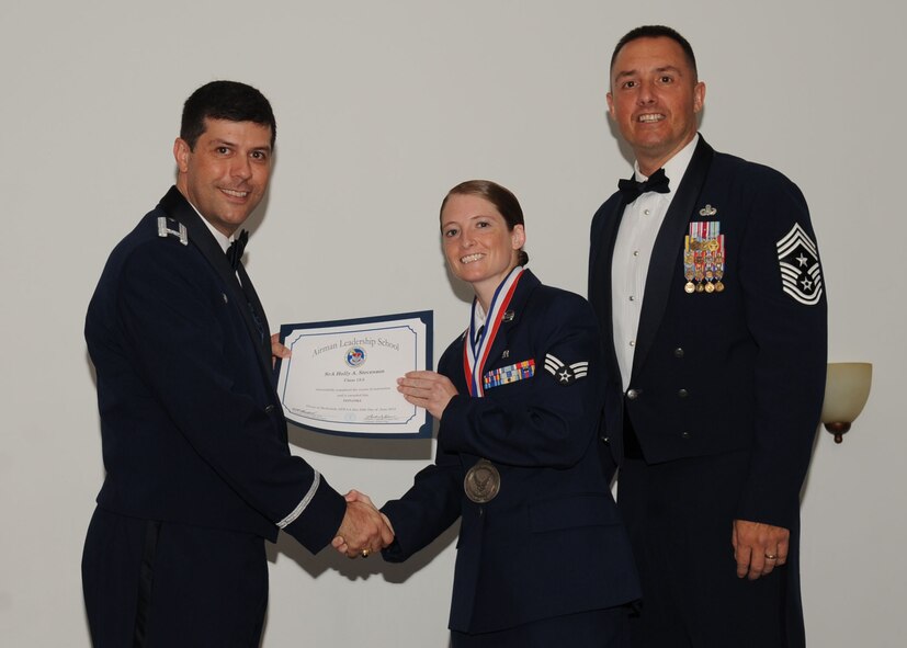 Senior Airman Holly Stevenson, 26th Operational Weather Squadron, receives an Airman Leadership School graduation certificate from Col. Andrew Gebara, 2nd Bomb Wing commander, on Barksdale Air Force Base, La., June 21, 2013. (U.S. Air Force photo).