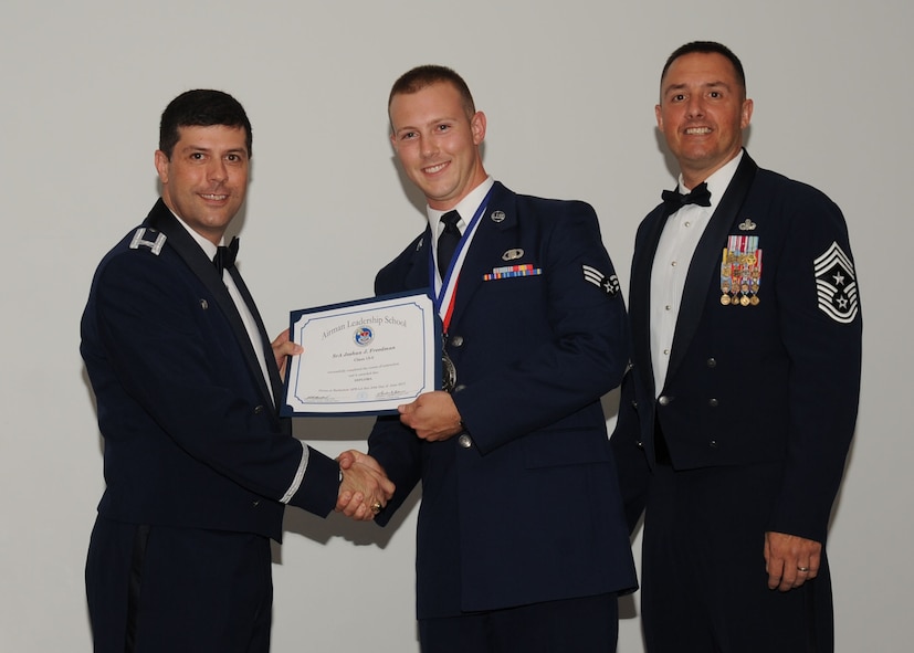 Senior Airman Joshua Freedman, 608th Air Operations Center, receives an Airman Leadership School graduation certificate from Col. Andrew Gebara, 2nd Bomb Wing commander, on Barksdale Air Force Base, La., June 21, 2013. (U.S. Air Force photo).