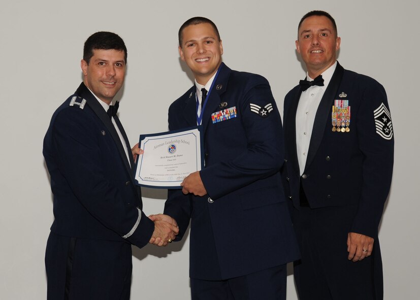 Senior Airman Stuart Dame, 302nd Civil Engineer Squadron, receives an Airman Leadership School graduation certificate from Col. Andrew Gebara, 2nd Bomb Wing commander, on Barksdale Air Force Base, La., June 21, 2013. (U.S. Air Force photo).