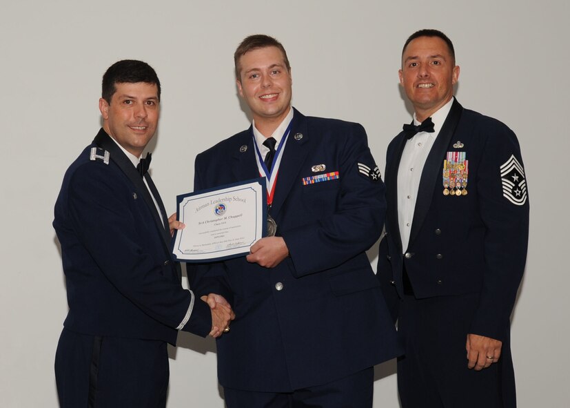 Senior Airman Christopher Chappell, 2nd Air Communications Squadron, receives an Airman Leadership School graduation certificate from Col. Andrew Gebara, 2nd Bomb Wing commander, on Barksdale Air Force Base, La., June 21, 2013. (U.S. Air Force photo).
