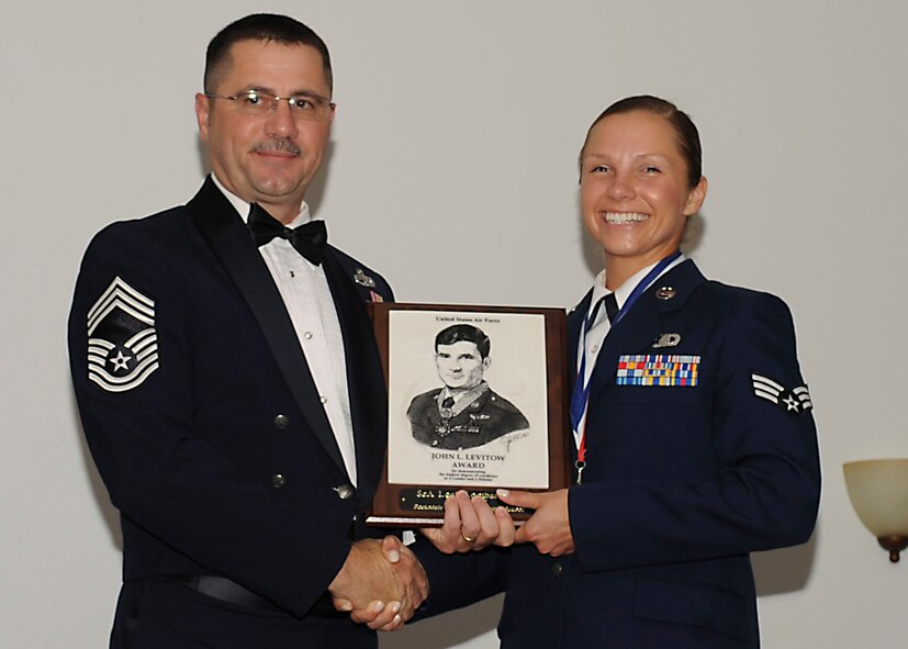 Senior Airman Leah Lombardozzi, 608th Air Operations Center, receives the John Levitow Award from Chief Master Sgt. Richard Young, 707th Maintenance Squadron, during the Airman Leadership School class 13-5 graduation on Barksdale Air Force Base, La., June 21, 2013.