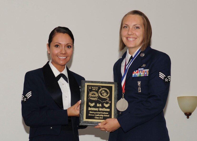 Senior Airman Brittany Arellano, 2nd Munitions Squadron, receives the Distinguished Graduate Award from Senior Airman Karina Reyes, 2nd Contracting Squadron, on behalf of the Air Force Sergeants Association during the Airman Leadership School Class 13-5 Graduation on Barksdale Air Force Base, La., June 21, 2013. (U.S. Air Force photo)