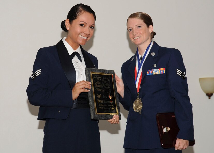 Senior Airman Holly Stevenson, 26th Operational Weather Squadron, receives the Distinguished Graduate Award from Senior Airman Karina Reyes, 2nd Contracting Squadron, on behalf of the Air Force Sergeants Association during the Airman Leadership School Class 13-5 Graduation on Barksdale Air Force Base, La., June 21, 2013. (U.S. Air Force photo)