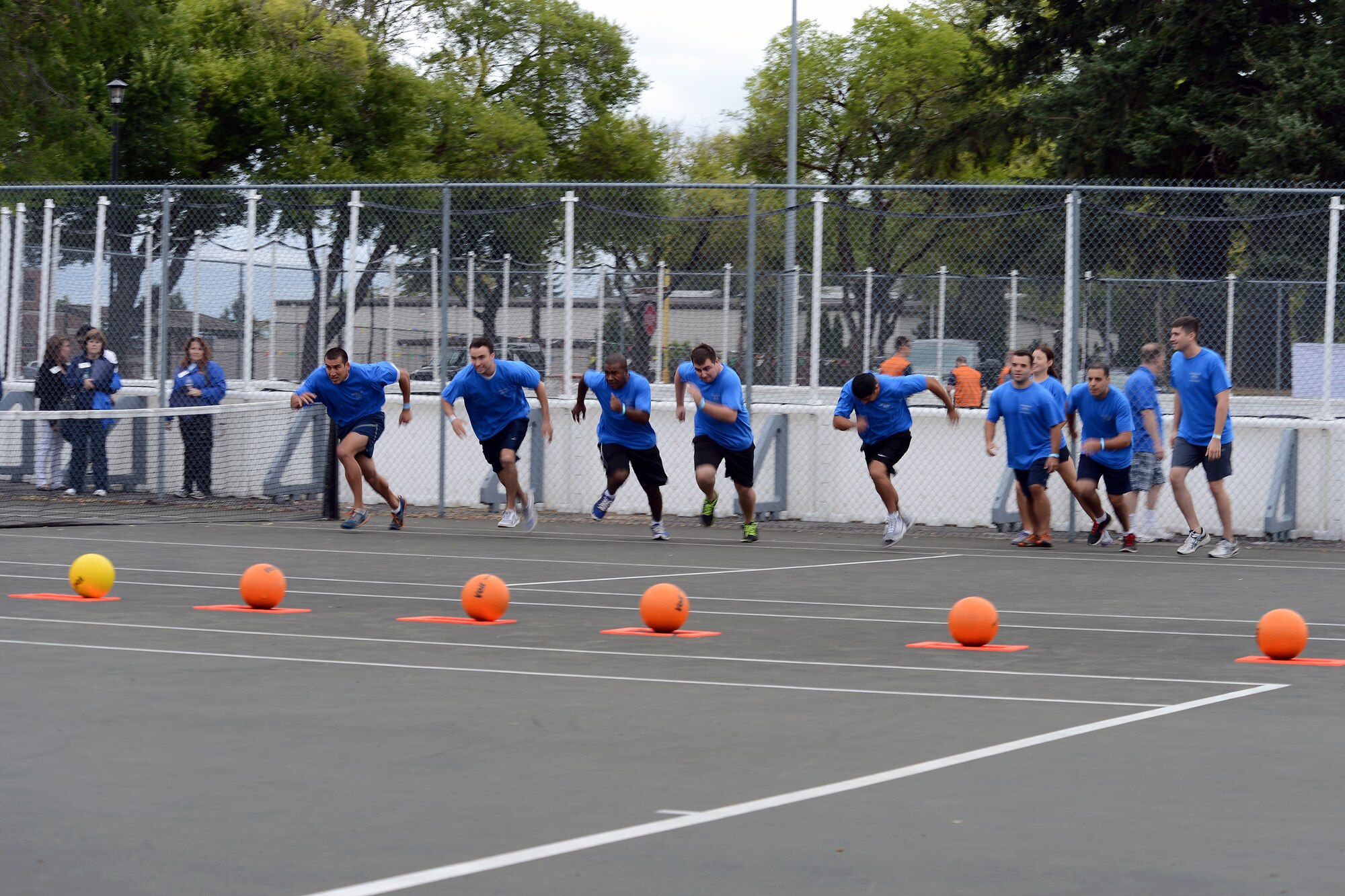 Airmen of the 62nd Operations Support Squadron run to a line of dodge balls Aug. 23, 2013 during the Team McChord Sports Day at Joint Base Lewis-McChord, Wash. The day’s different games included a Nerf gun challenge, beach volleyball, ultimate frisbee, relay races, kick ball and a truck pull. (U.S. Air Force photo/Airman 1st Class Jacob Jimenez)