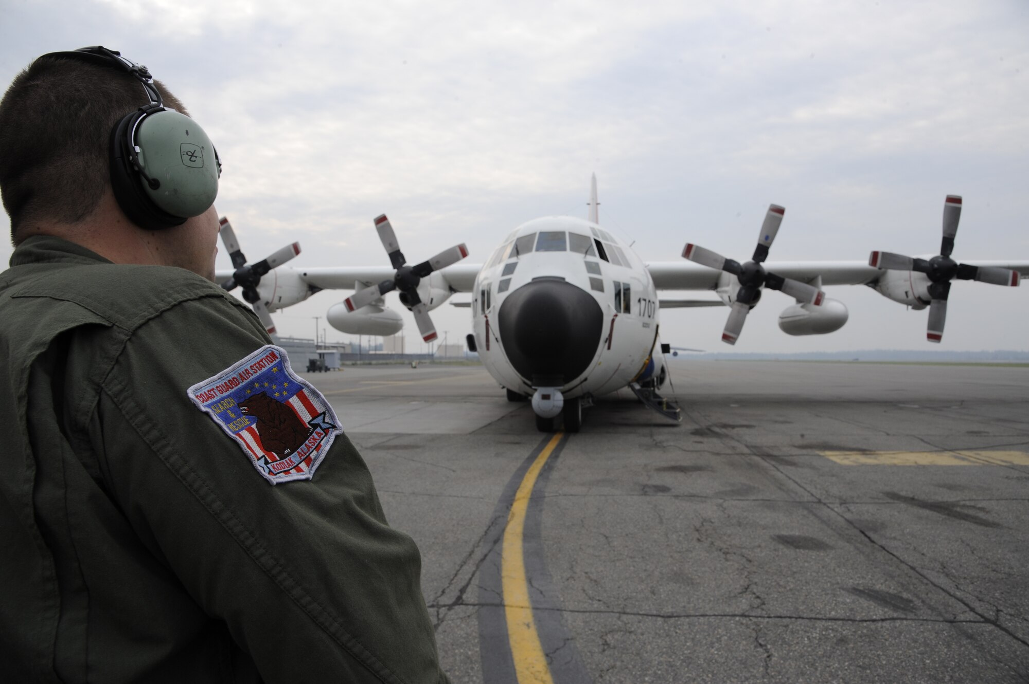 An aviation maintenance technician communicates with pilots as they perform a low-speed ground idle engine run to test repairs to an engine Aug. 15, 2013, Eielson Air Force Base, Alaska. The U.S. Coast Guard HC-130H Hercules aircrew visited Eielson recently as part of a flying mission to and above the Arctic Circle. The crew of eight, along with eight civilian scientists, arrived the first week of RED FLAG-Alaska 13-3 operations.  (U.S. Air Force photo by Airman 1st Class Peter Reft/Released) 

