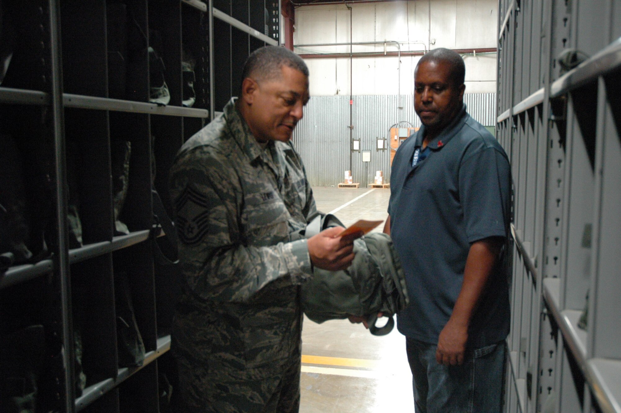 Chief Master Sgt. Jerome Lewis, 10th Air Force A4/A7 Management Supervisor, examines the maintenance log on a piece of chemical warfare gear during his tour of a warehouse at Beale Air Force Base, Calif., Aug. 22, 2013, as Maceo Lynch, 9th Mission Support Group Mobility Readiness Control Center supervisor, looks on.  During his site visit to the 940th Wing, Lewis met with the reserve unit’s logistics readiness squadron to discuss program and personnel management. (U.S. Air Force photo/Dana Lineback)