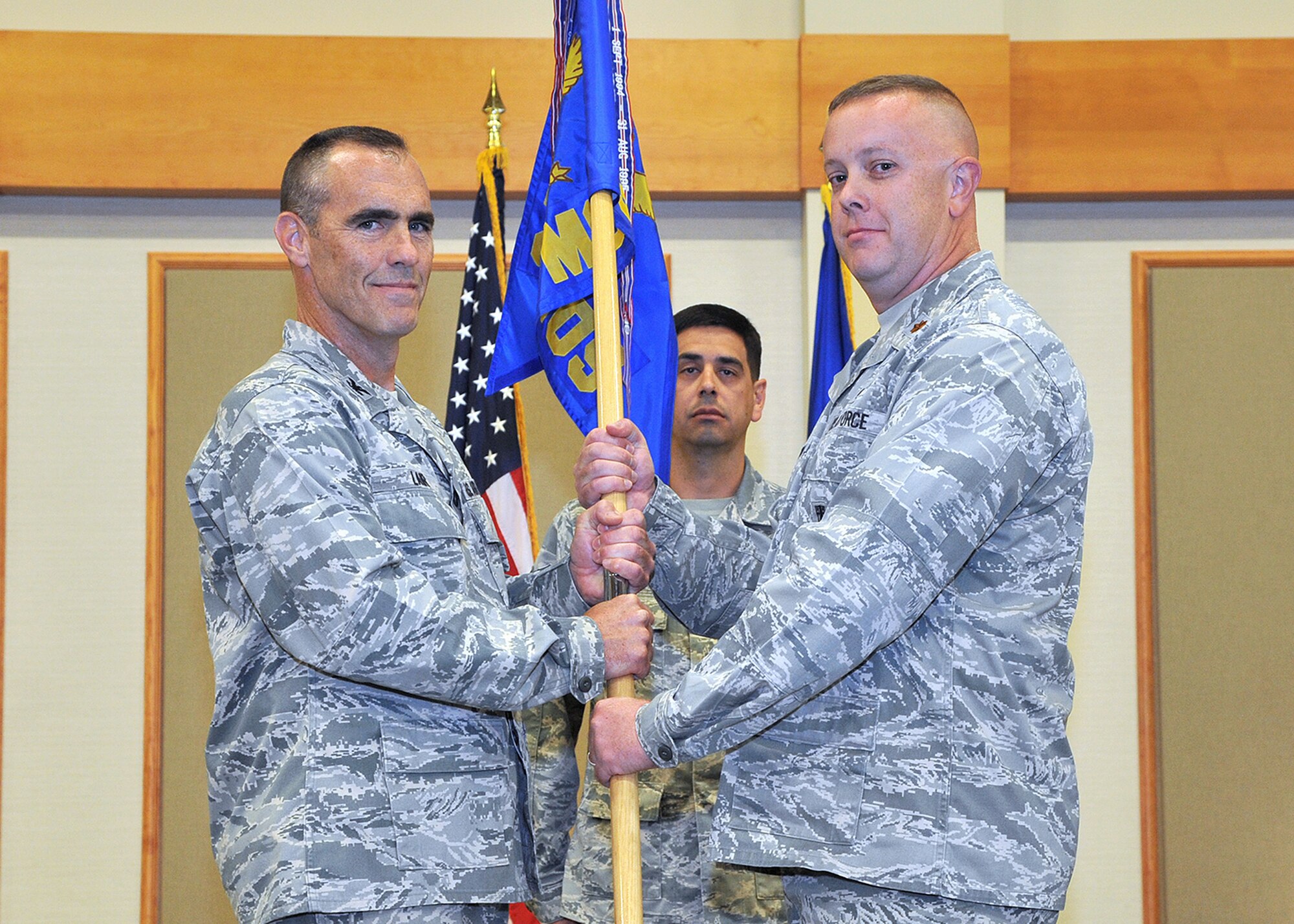 Maj. John Briner, right, accepts command of the 341st Maintenance Operations Squadron from Col. David Lair, 341st Maintenance Group commander, at the Grizzly Bend on Aug. 21.  Master Sgt. Scott Strieby, 341st MOS first sergeant, looks on.  (U.S. Air Force photo/ John Turner)