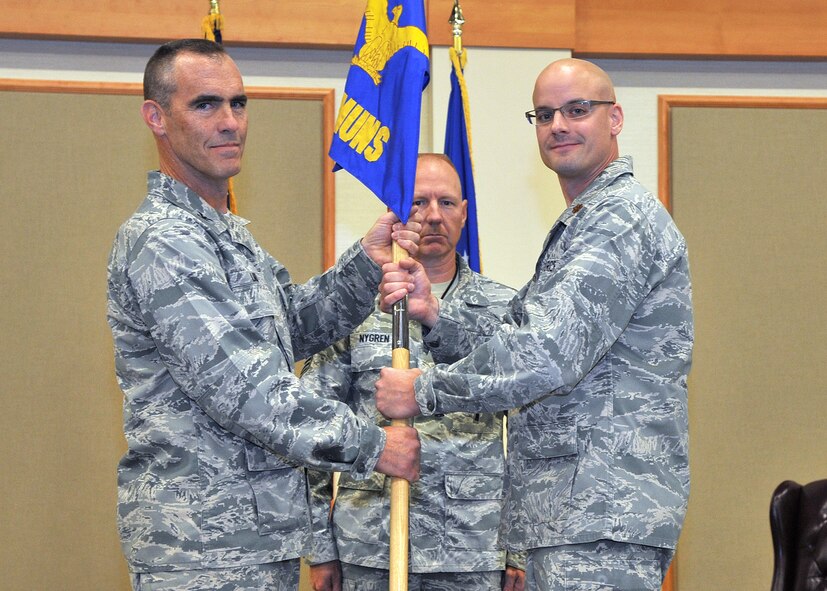 Maj. Joseph Komensky Jr., right, accepts command of the 341st Munitions Squadron from Col. David Lair, 341st Maintenance Group commander, at the Grizzly Bend on Aug. 20.  Chief Master Sgt. William Nygren, 341st MUNS superintendent, looks on.  (U.S. Air Force photo/ John Turner)