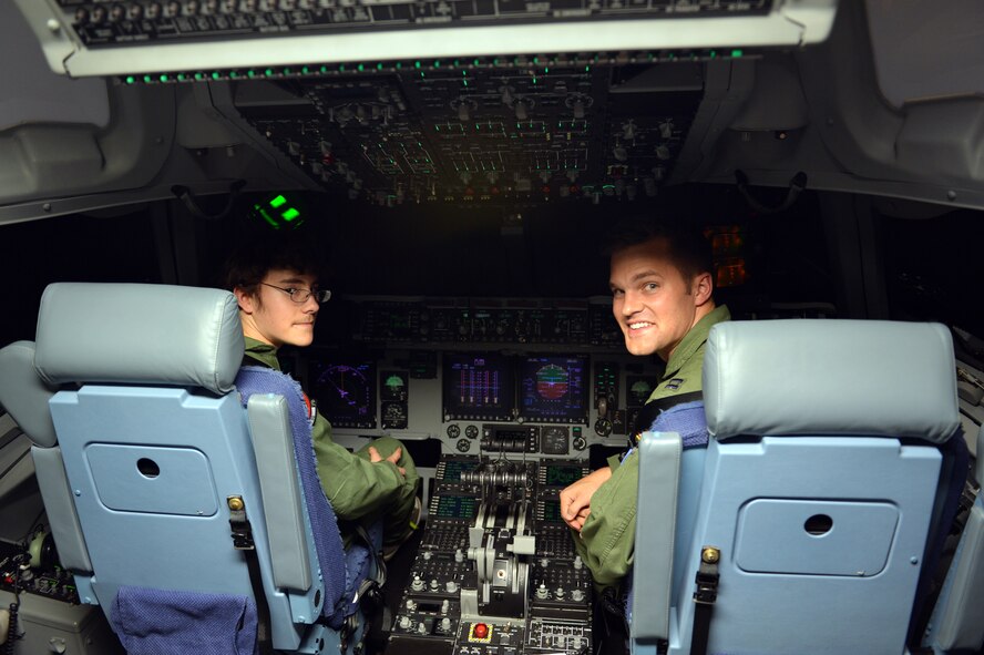 Christian Ball (left), Pilot for a Day recipient, and Capt. Mike Knapp, 4th Airlift Squadron awards and decorations officer, turn around in their seats to tell the simulator instructor operator they are ready to start their flight Aug. 22, 2013 at Joint Base Lewis-McChord, Wash. Christian and Knapp took a simulated flight around the local area and finished by landing at Moses Lake, Wash. (U.S. Air Force photo/Staff Sgt. Jason Truskowski)