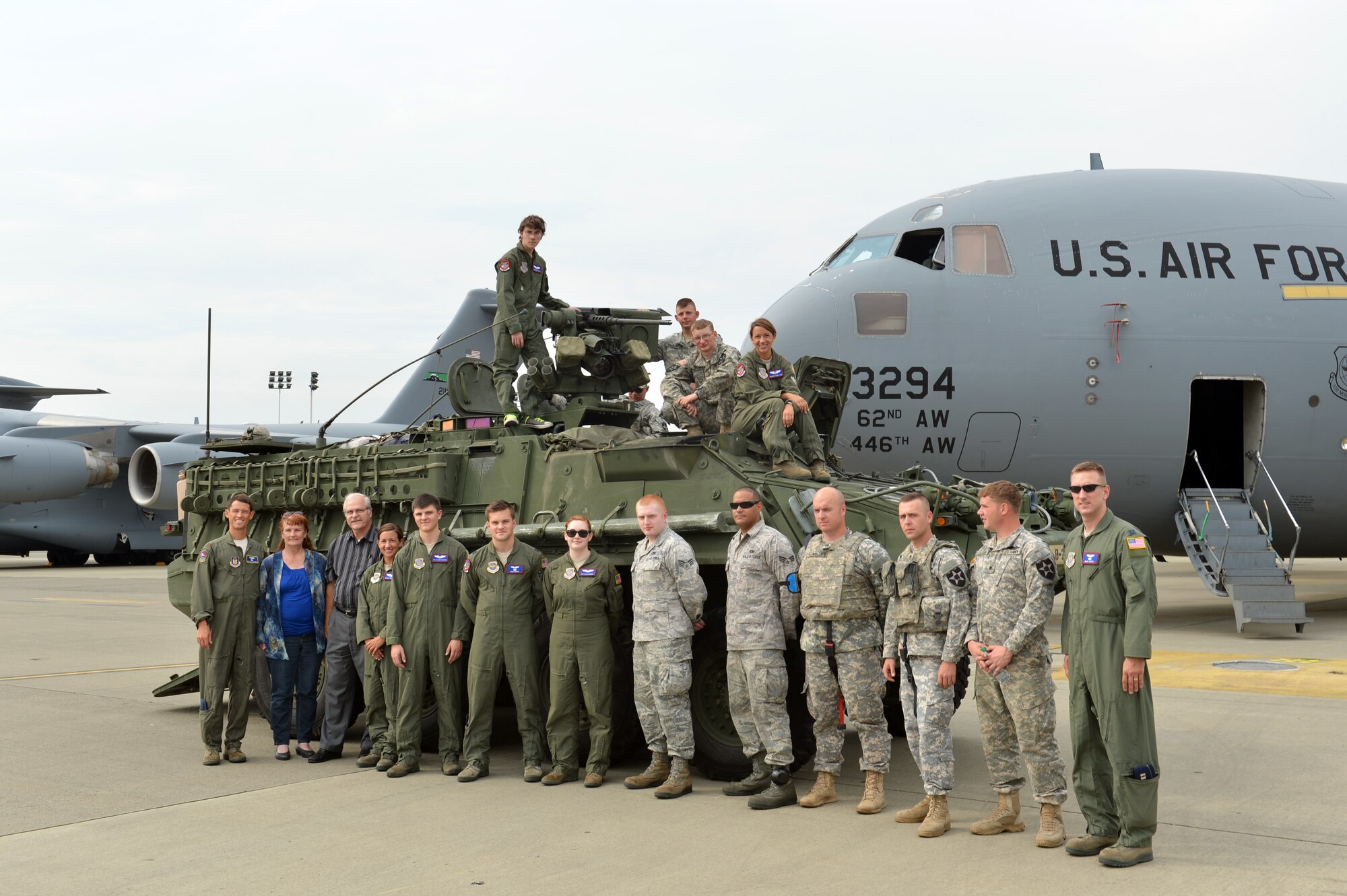 Military members that made Christian Ball’s Pilot for a Day possible, pose with him in front of a Stryker and C-17 Globemaster III aircraft Aug. 22, 2013 at Joint Base Lewis-McChord, Wash. The 4th Airlift Squadron has hosted the Pilot for a Day program since 2010. (U.S. Air Force photo/Staff Sgt. Jason Truskowski)