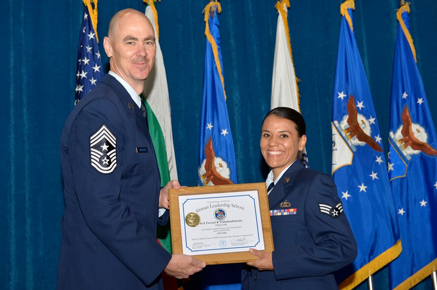 McGHEE TYSON AIR NATIONAL GUARD BASE, Tenn. - Senior Airman Vernal K. Villahashimoto, right, from Hawaii ANG, receives the Distinguished Graduate Award for Airman Leadership School Class 13-6 from Chief Master Sgt. Ronald C. Anderson, Jr., 1st Air Force (Air Forces Northern), Tyndall Air Force Base, Fla. here, Aug. 15, 2013. The award is presented to students in the top 10 percent of their class and is based on objective and performance evaluations, demonstrated leadership and participation as a team player. (U.S. Air National Guard photo by Master Sgt. Kurt Skoglund/Released)