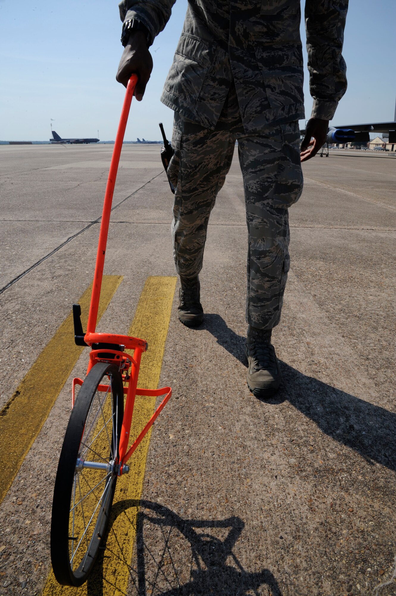 Airman 1st Class Marcus Jackson, 2nd Operations Support Squadron airfield management apprentice, uses a measuring wheel on Barksdale Air Force Base, La., Aug. 23, 2013. The wheel is used to measure taxi lane edge markings in order to ensure the markings are in compliance. (U.S. Air Force photo/Airman 1st Class Andrew Moua)