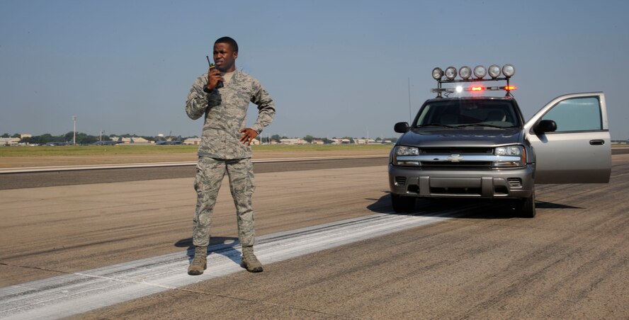 Airman 1st Class Marcus Jackson, 2nd Operations Support Squadron airfield management apprentice, communicates with the air traffic control tower on Barksdale Air Force Base, La., Aug. 23, 2013. Jackson communicated with the tower to relay information about potential hazards to inbound and outbound aircraft. (U.S. Air Force photo/Airman 1st Class Andrew Moua)