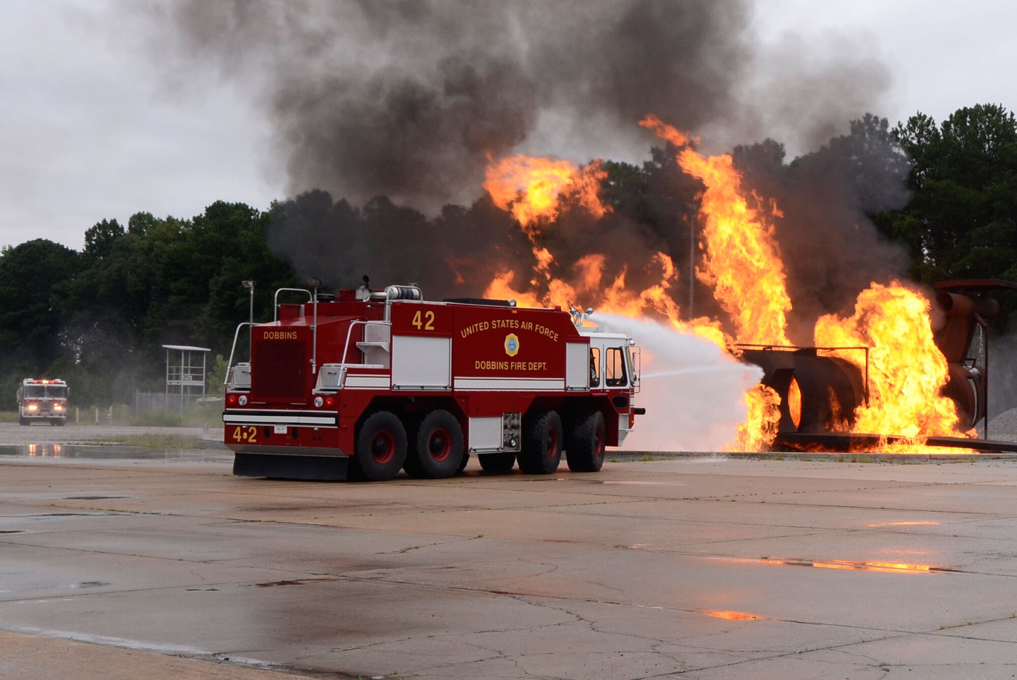 The Dobbins Fire Department crash response team performs a simulated aircraft fire demonstration for local Honorary Commanders Association members touring Dobbins Air Reserve Base, Ga., Aug. 21.  Dobbins Day program HCA attendees  experienced additional base sites including the Eastern Regional C-130 Simulator, Force Support Combat Training Center, base operations, weather station and air traffic control tower, as well as static displays by Explosive Ordnance Disposal team, C-130 Hercules air crews and briefings from 94th Aeromedical Evacuation Squadron personnel. (U.S. Air Force photo/Don Peek)