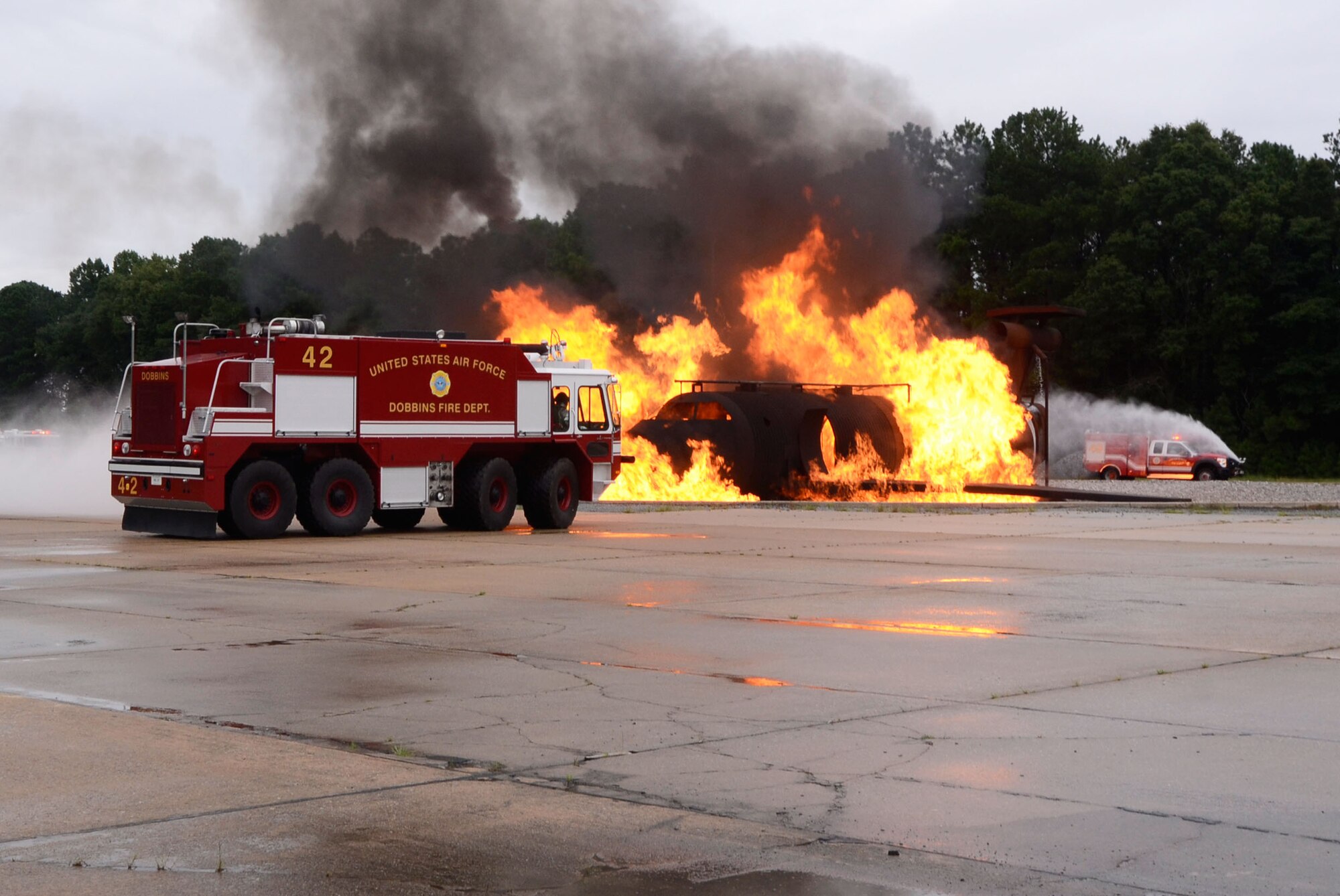 The Dobbins Fire Department crash response team performs a simulated aircraft fire demonstration for local Honorary Commanders Association members touring Dobbins Air Reserve Base, Ga., Aug. 21.  Dobbins Day program HCA attendees  experienced additional base sites including the Eastern Regional C-130 Simulator, Force Support Combat Training Center, base operations, weather station and air traffic control tower, as well as static displays by Explosive Ordnance Disposal team, C-130 Hercules air crews and briefings from 94th Aeromedical Evacuation Squadron personnel. (U.S. Air Force photo/Don Peek)