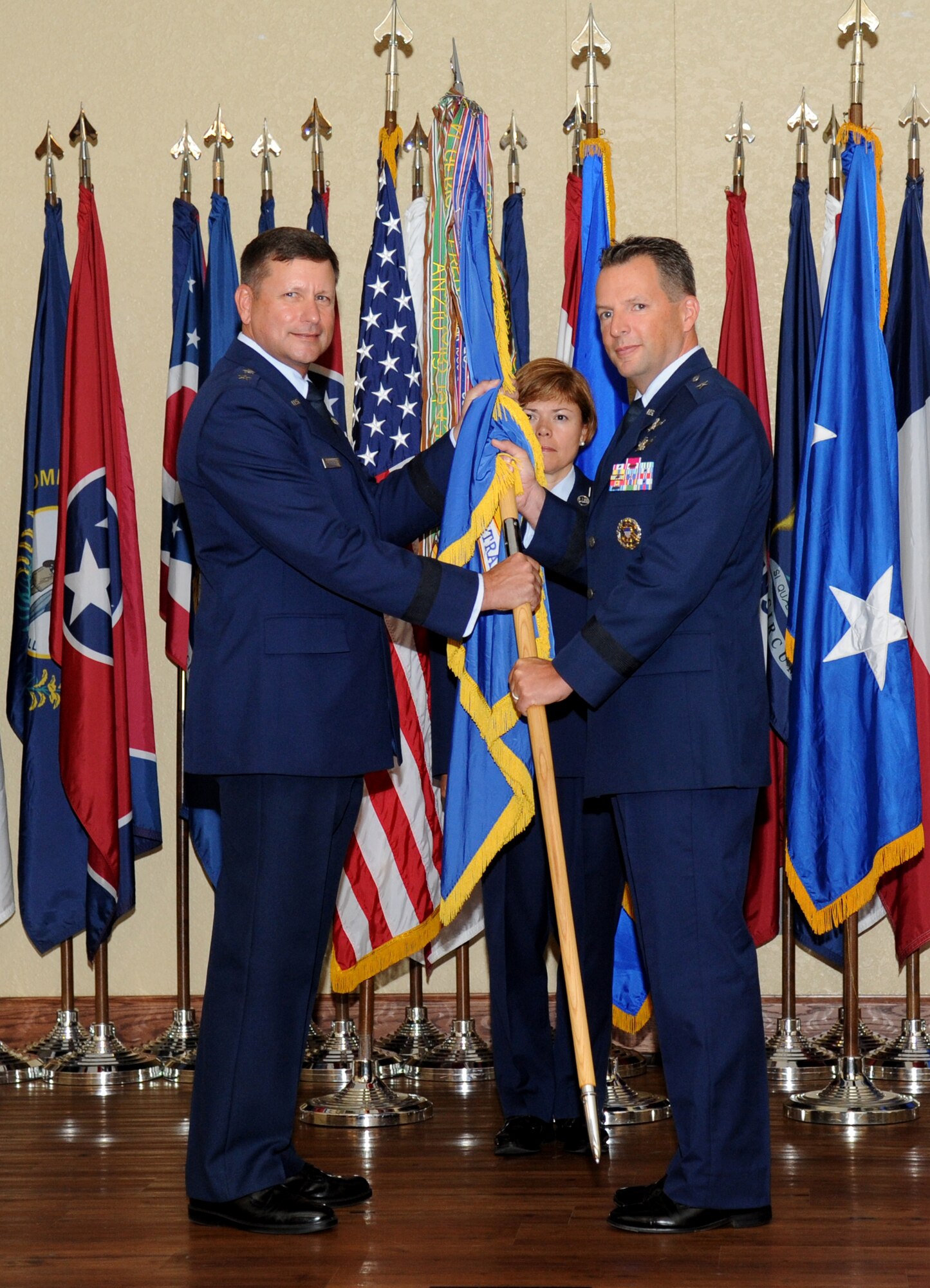 Maj. Gen. Leonard Patrick, 2nd Air Force commander, passes the guidon to Brig. Gen. Patrick Higby, incoming 81st Training Wing commander, during a change of command ceremony Aug. 23, 2013, at the Bay Breeze Event Center, Keesler Air Force Base, Miss.  Brig. Gen. Brad Spacy, outgoing 81st TRW commander, has been selected for a new assignment as director for logistics, installations and mission support at Headquarters United States Air Forces in Europe, Ramstein Air Base, Germany.  (U.S. Air Force photo by Kemberly Groue)