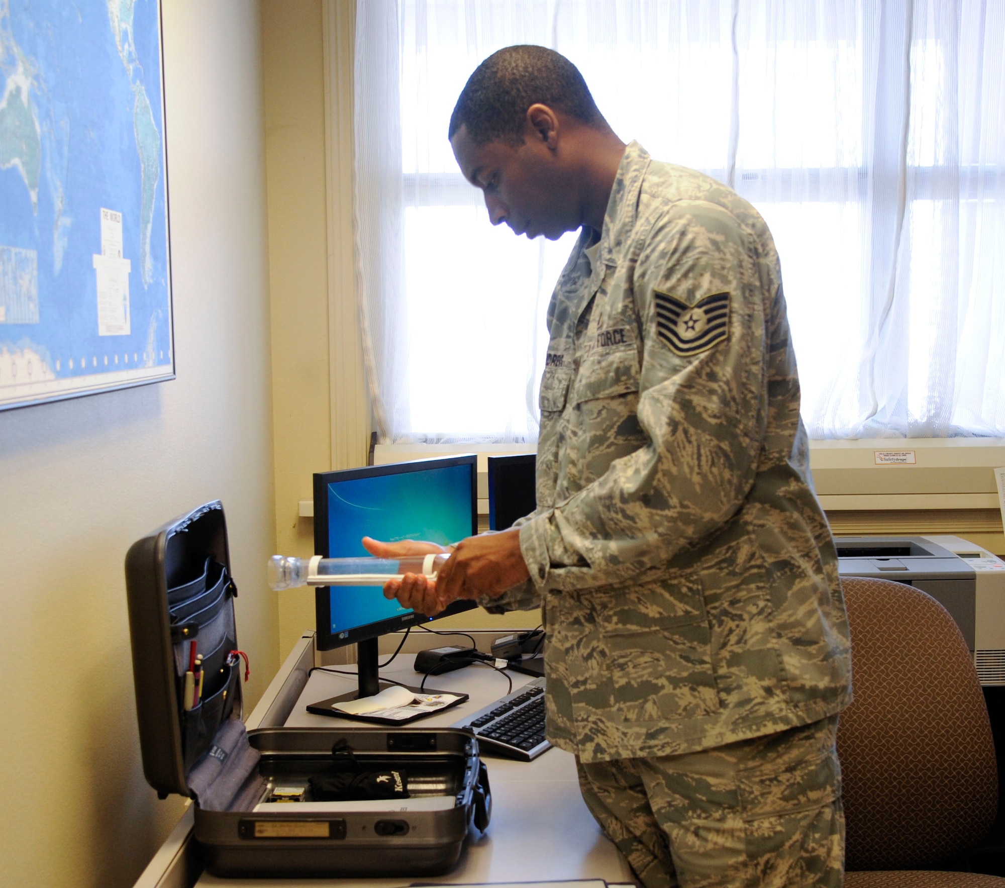 Tech. Sgt. Eric Andrews, 2nd Operations Support Squadron weather technician, inspects the contents of a weather evacuation kit on Barksdale Air Force Base, La., Aug. 22, 2013. The kit contains all the equipment needed in case of an emergency where personnel must vacate the building such as a kestrel, compass, and rain gauge. (U.S. Air Force photo/Airman 1st Class Andrew Moua)