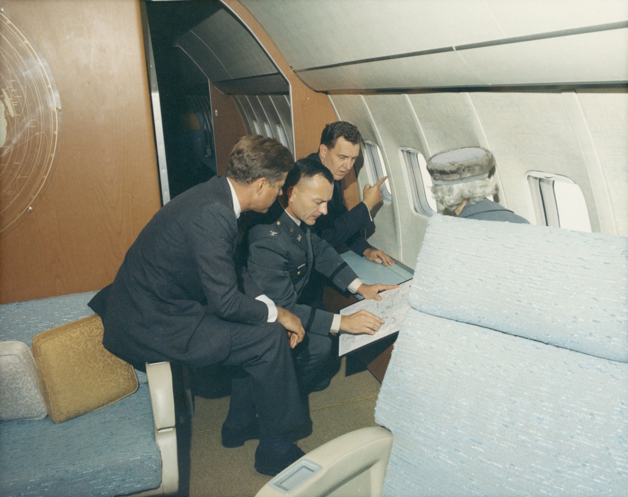 President John F. Kennedy with the two U.S. Senators from Maine, Edmund Muskie and Margaret Chase Smith, and Col Robert C. Marshall (U,S, Army Corps of Engineers) on SAM 26000 as it overflew the Passamaquoddy Tidal Basin in Maine on Oct. 19, 1963. Note the glare from the camera flash behind and above, right.  (Photo courtesy of JFK Library)