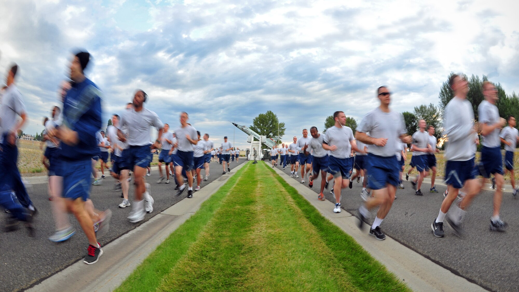 Airmen race off the starting line during the wing run at Fairchild Air Force Base, Wash., Aug. 23, 2013. The run covered a 1.8 mile length, starting at the F-102A Delta Dagger static display. (U.S. Air Force photo illustration by Senior Airman Taylor Curry/Released)
