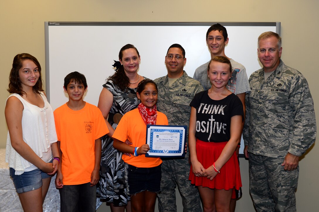 U.S. Air Force Col. John J. Allen Jr., 633rd Air Base Wing commander (far right), presents Meloni Rivera and her family with the U.S. Air Forces in Europe Key Spouse of the Year Award for 2012.  Rivera expanded the Logistics Readiness Squadron’s Key Spouse Program, established the LRS Key Spouses’ Facebook page, coordinated dorm events for unaccompanied Airmen and organized numerous activities for families of deployed Service members while stationed at the 100th Air Refueling Wing at Royal Air Force Mildenhall, England. (U.S. Air Force photo by Senior Airman Kayla Newman/Released)