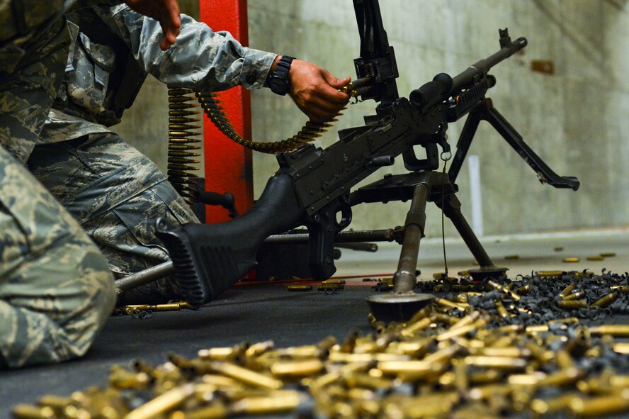 Airman 1st Class Skyler Mills, 56th SFS, reloads the M-240B machine gun for Airman 1st Class Julius Prefontaine-Gomez, 56th SFS, while Gomez qualifies on the weapon. (U.S. Air Force photo/Senior Airman David Owsianka)